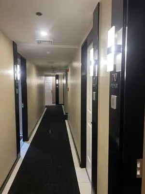 a hallway with doors and a black carpet at Hotel Sogo EDSA Shaw Blvd in Manila