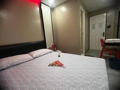 a bedroom with a white bed with a red packet on it at Hotel Sogo EDSA Shaw Blvd in Manila