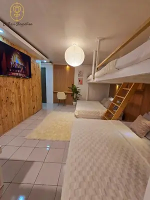 a room with two bunk beds and a desk at El Nissi Staycation, THE BARIQUIT SUITE, Enchanted Kingdom in Santa Rosa
