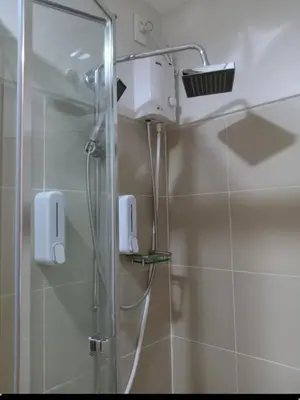 a shower with a shower head in a bathroom at One Bedroom Unit in Fame Residences in Manila