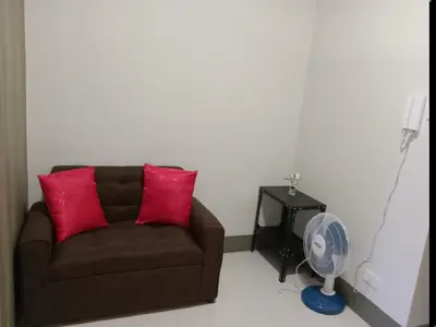 a living room with a couch and a fan at One Bedroom Unit in Fame Residences in Manila