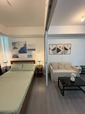 a bedroom with two beds and a couch at Sunset and Breeze by Azure in Manila