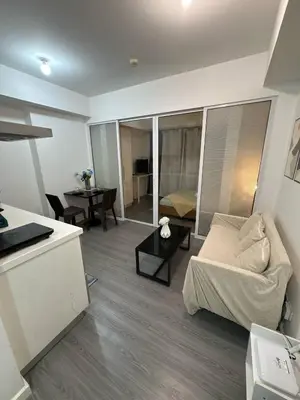 a living room with a couch and a table at Sunset and Breeze by Azure in Manila