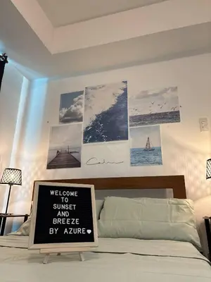 a bedroom with a bed with a sign on the wall at Sunset and Breeze by Azure in Manila