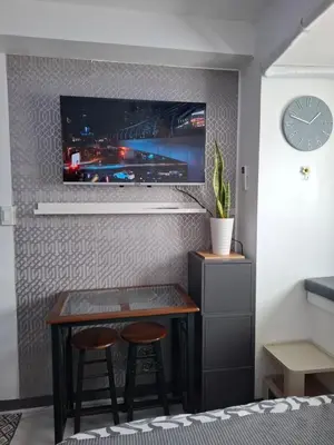 a room with a table and two stools and a tv at QUINS STAYCATION One Bedroom at SMDC South Residences in Manila