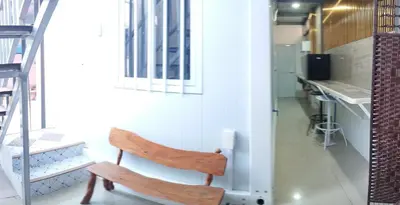 a wooden chair sitting in a room with a kitchen at 6 Guest - Unit 4 Studio Type - Container house in Santa Rosa