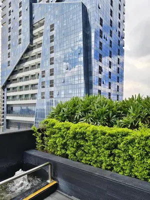a bench in front of a tall building at Gramercy Residences Makati by Christine Suites PH with Balcony in Manila