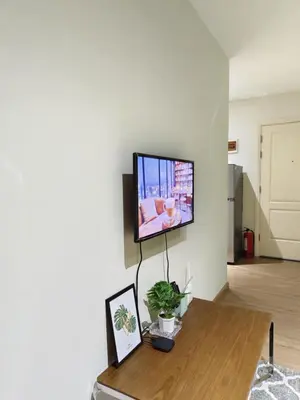 a living room with a flat screen tv on a wall at Gramercy Residences Makati by Christine Suites PH with Balcony in Manila