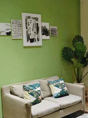 a couch in a living room with green walls at Gramercy Residences Makati by Christine Suites PH with Balcony in Manila