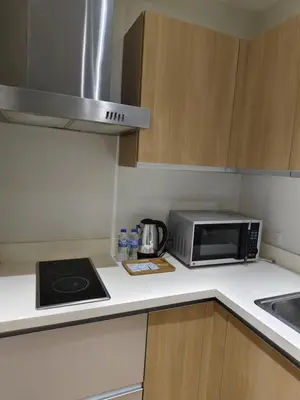 a small kitchen with a microwave and a sink at Gramercy Residences Makati by Christine Suites PH with Balcony in Manila