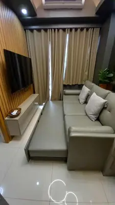 a living room with a couch and a flat screen tv at Cozy and Luxurious Condominium in Manila