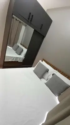 a bedroom with a large white bed and a mirror at Cozy and Luxurious Condominium in Manila