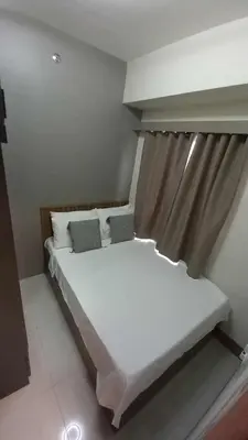 a bedroom with a white bed with a curtain at Cozy and Luxurious Condominium in Manila