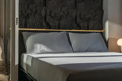 a bed with blue pillows and a black headboard at Casa Attila - Azure Urban Resort Residences in Manila