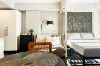 a bedroom with a bed and a table and a chair at Casa Attila - Azure Urban Resort Residences in Manila