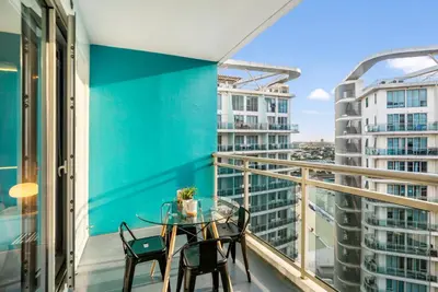 a balcony with a table and chairs and a view of buildings at Casa Attila - Azure Urban Resort Residences in Manila