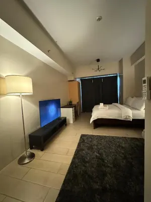 a bedroom with a bed and a lamp and a television at 81 Newport Blvd Cluster 5 unit 5K by Rechelle Nunag in Manila