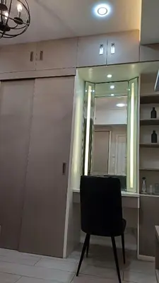 a black chair sitting in front of a mirror at 1 Master BR with full bathroom and JET TUB plus 2nd BR with full bathroom Elegant fully furnished with hotel feels in Manila