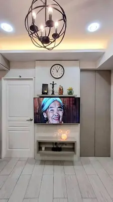 a living room with a television with a woman on it at 1 Master BR with full bathroom and JET TUB plus 2nd BR with full bathroom Elegant fully furnished with hotel feels in Manila