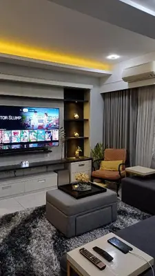a living room with a large flat screen tv at 1 Master BR with full bathroom and JET TUB plus 2nd BR with full bathroom Elegant fully furnished with hotel feels in Manila