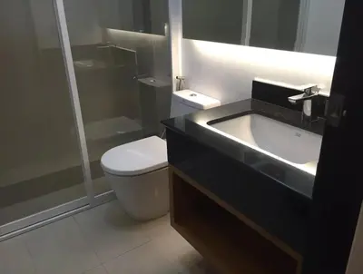 a bathroom with a toilet and a sink and a shower at Plant Box Apartment in Manila