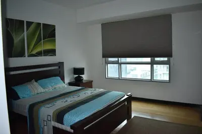 a bedroom with a bed with a large window at Plant Box Apartment in Manila