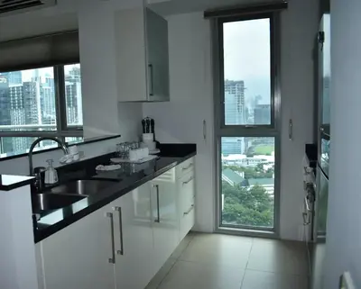 a kitchen with a sink and a large window at Plant Box Apartment in Manila
