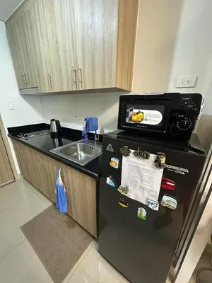 a kitchen with a black refrigerator and a sink at Smdc shore 2 tower 2 in Manila