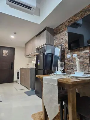 a kitchen with a wooden table and a refrigerator at Condo Suite 1 Bedroom McKinley West Taguig City in Manila