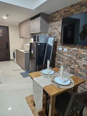 a kitchen with a table with chairs and a refrigerator at Condo Suite 1 Bedroom McKinley West Taguig City in Manila