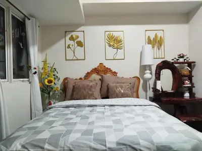 a bedroom with a bed and some pictures on the wall at Condo Suite 1 Bedroom McKinley West Taguig City in Manila