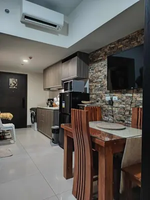 a kitchen with a table with chairs and a tv at Condo Suite 1 Bedroom McKinley West Taguig City in Manila