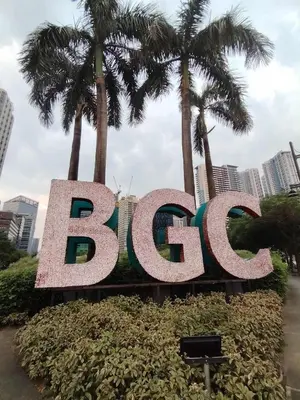 a sign for the btec sign in front of palm trees at Condo Suite 1 Bedroom McKinley West Taguig City in Manila