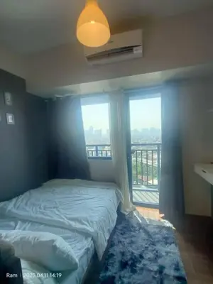 a bedroom with a bed and a window with a view at AIR Residences Makati Holiday Home in Manila