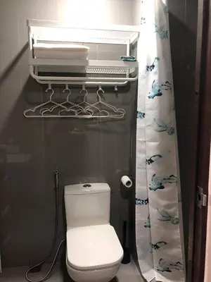 a bathroom with a white toilet and a shower curtain at AIR Residences Makati Holiday Home in Manila