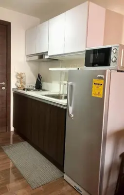 a kitchen with a stainless steel refrigerator and white cabinets at AIR Residences Makati Holiday Home in Manila