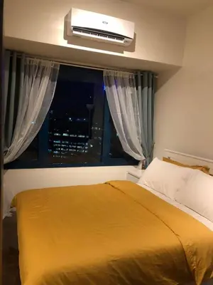 a bedroom with a bed and a window with at AIR Residences Makati Holiday Home in Manila