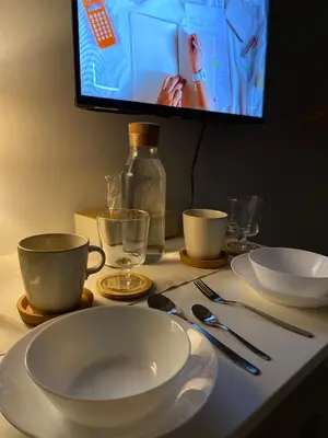 a table with plates and utensils and a tv at Prime Location Affordable Studio Condo in Legaspi village, Makati with Fast WiFi in Manila