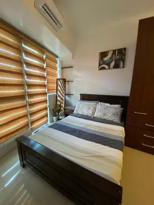 a bedroom with a bed and a large window at Prime Location and Affordable Studio Condo in Legaspi Village, Makati with City view in Manila