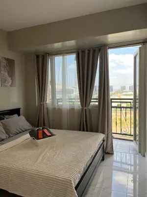 a bedroom with a bed and a large window at Monarch Park-suites Condominium in Manila