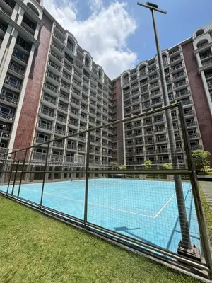 an empty tennis court in front of a large apartment building at Monarch Park-suites Condominium in Manila