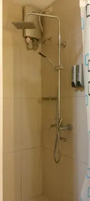 a shower with a shower head in a bathroom at Shell Residence in Manila