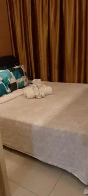 a bed with two towels and two glasses on it at Shell Residence in Manila