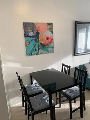 a dining room table and chairs with a painting on the wall at Fame Tower1 2-Bedrooms All Rms w Aircon Washer Balcony in Manila