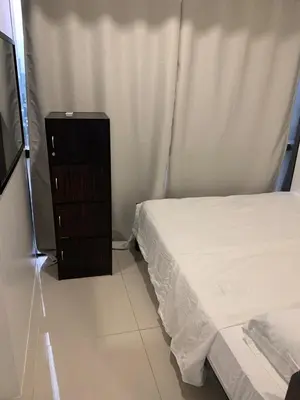 a small bedroom with a bed and a dresser at Fame Tower1 2-Bedrooms All Rms w Aircon Washer Balcony in Manila