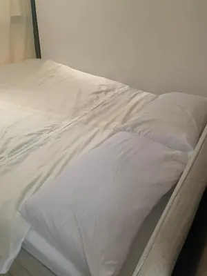 an unmade bed with white sheets and pillows at Fame Tower1 2-Bedrooms All Rms w Aircon Washer Balcony in Manila
