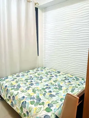 a bedroom with a bed with a flower patterned comforter at la Chicka - 295 T3 in Manila