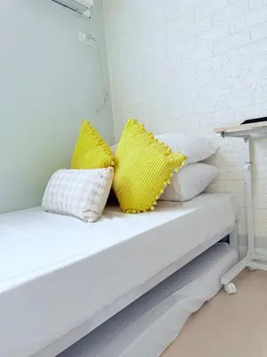 a white couch with yellow and white pillows on it at 42nd Floor 2BR with Stunning Views & 7 Pools in Manila