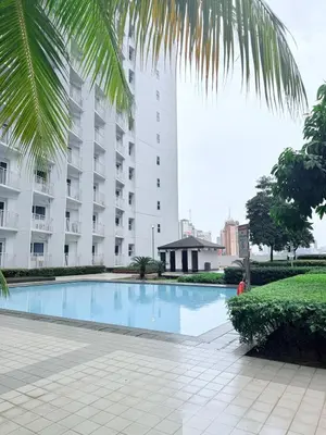 an empty swimming pool in front of a building at 42nd Floor 2BR with Stunning Views & 7 Pools in Manila