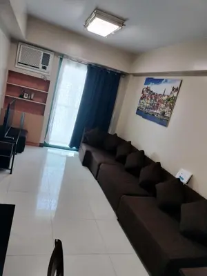 a living room with a couch and a window at 1 Bedroom Near Airport by Rqui in Manila